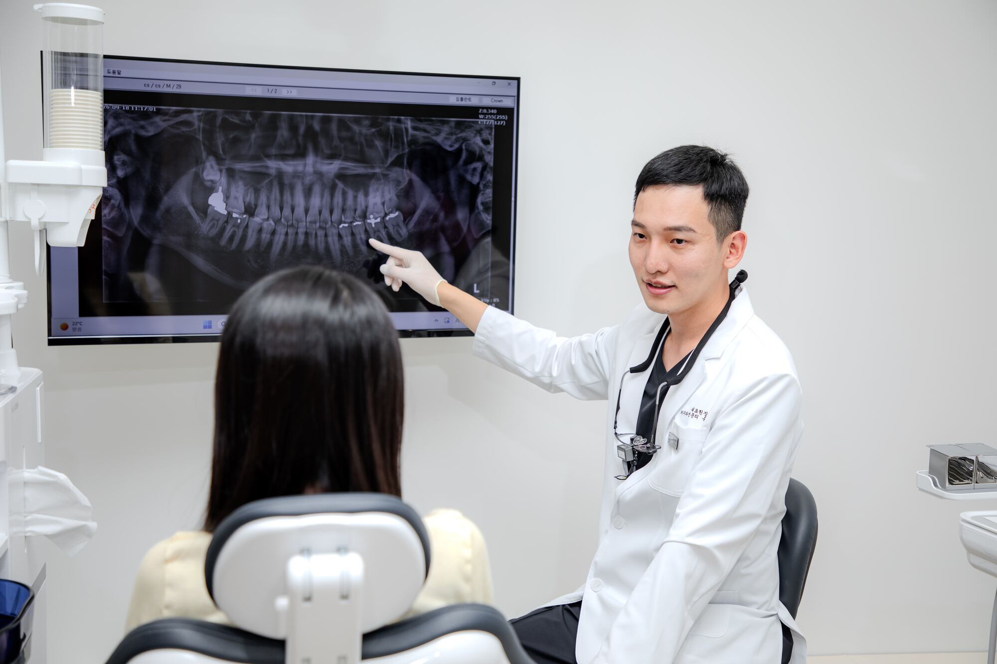 윤현필 대표원장이 파노라마 엑스레이를 가리키며 환자에게 설명하는 모습